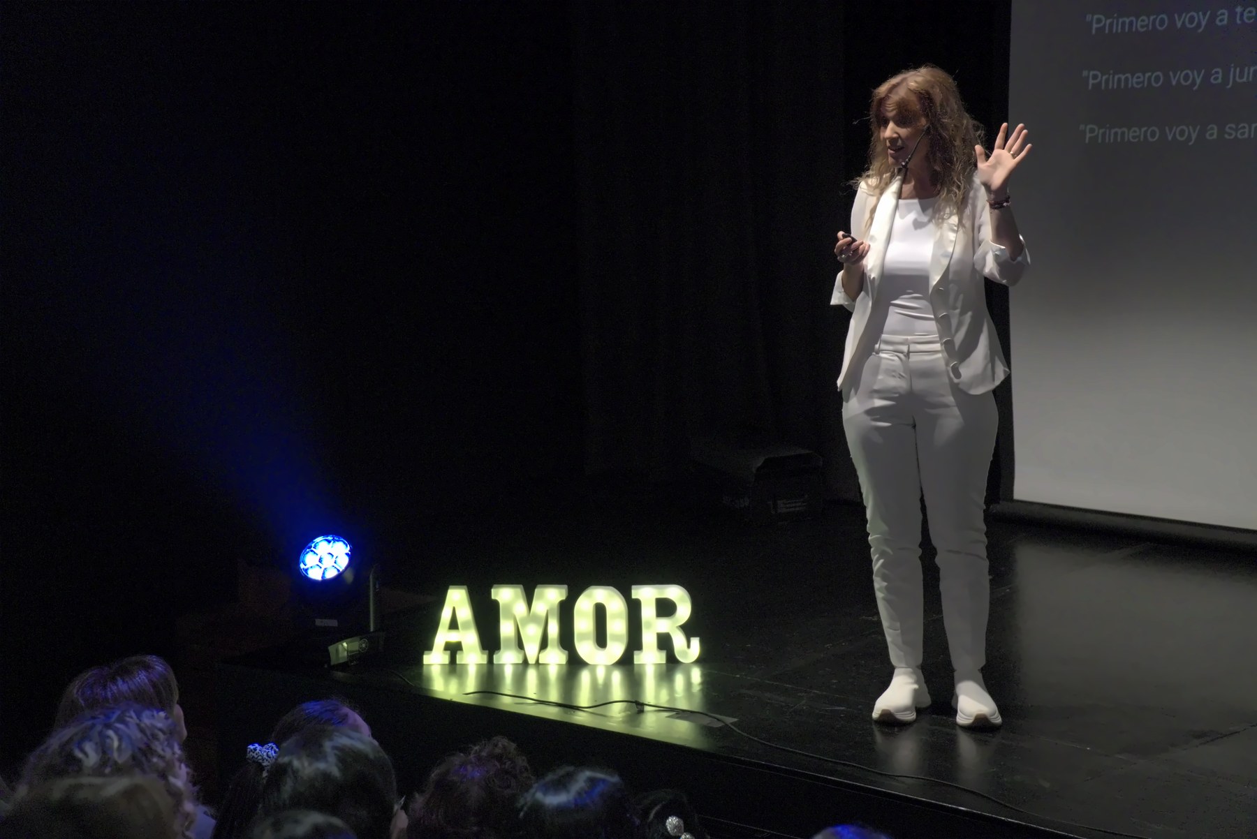 Xime en el escenario junto al letrero AMOR