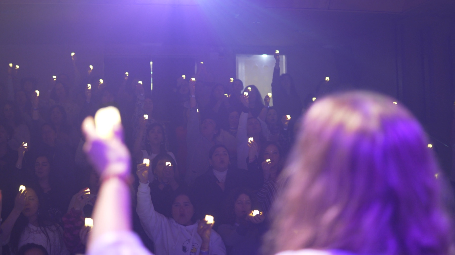 Participantes levantando velas durante un encuentro con Xime Rivera